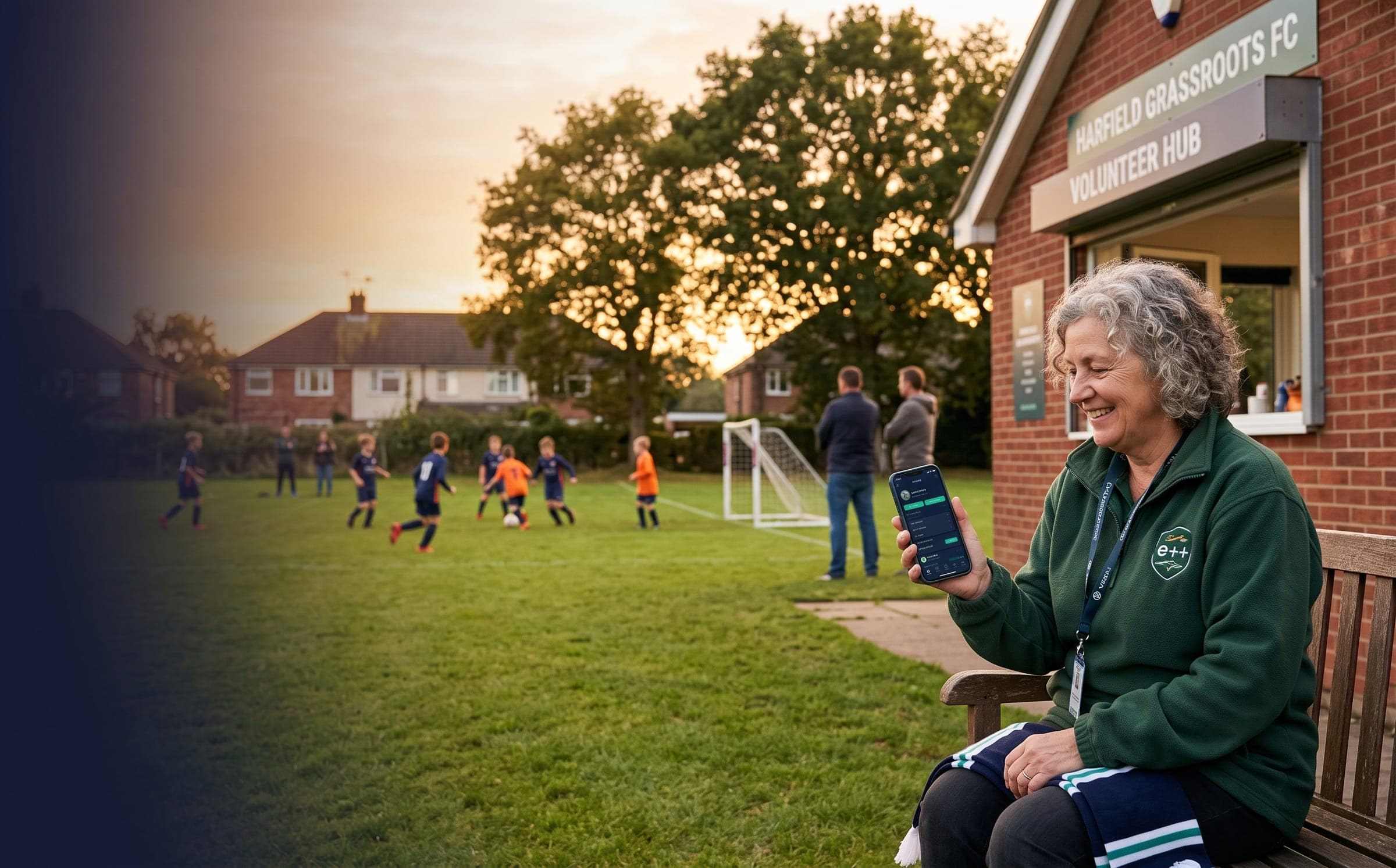 A club volunteer smiling at her savings on her phone, beside the clubhouse during a junior match